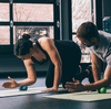 Two people rolling out forearms with rad roller soft